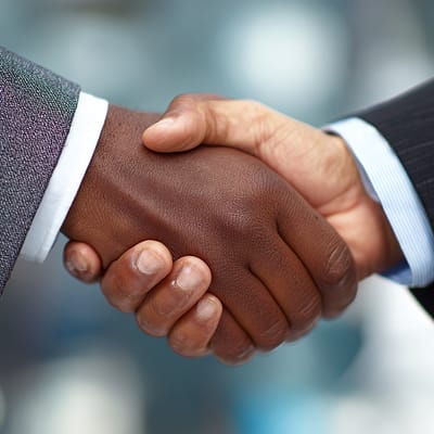 Handshake Agreement - Business Funding Partnership - Impelly Financial Two business professionals shaking hands after securing small business funding through Impelly Financial